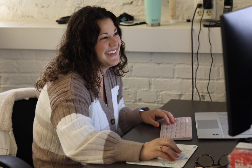 Aubree Halusic smiling at desk