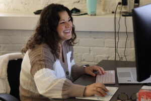 Aubree Halusic smiling at desk